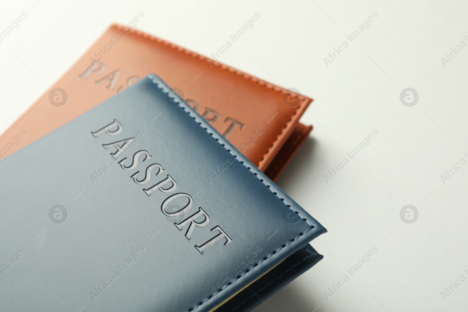 Photo of Passports in color covers on light background, closeup