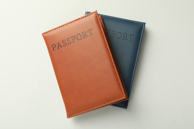 Photo of Passports in color covers on light background, top view