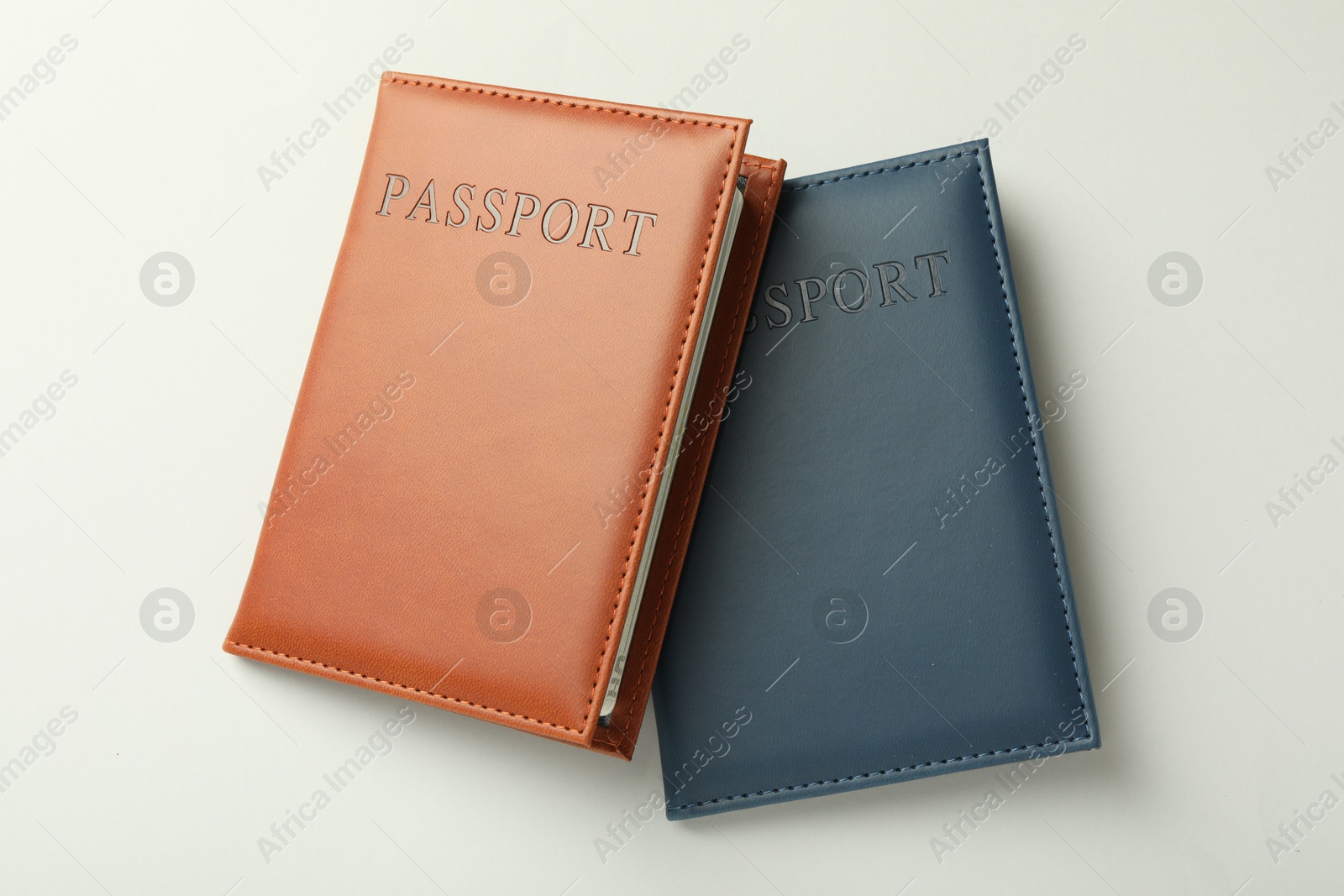 Photo of Passports in color covers on light background, top view