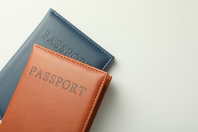 Photo of Passports in color covers on light background, top view. Space for text