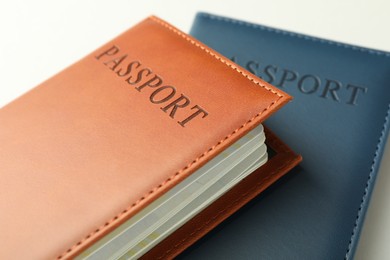 Photo of Passports in color covers on light background, closeup