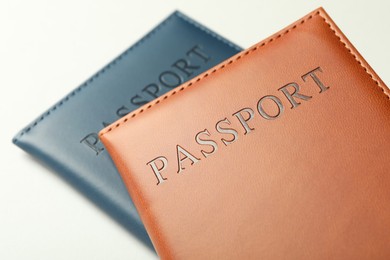 Photo of Passports in color covers on light background, closeup