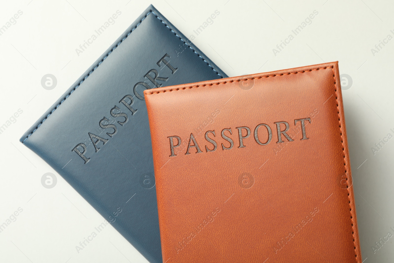 Photo of Passports in color covers on light background, top view