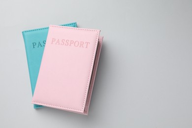 Photo of Passports in color covers on light background, top view. Space for text