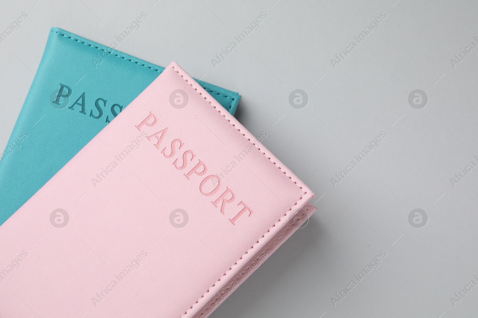 Photo of Passports in color covers on light background, top view. Space for text