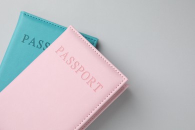 Photo of Passports in color covers on light background, top view. Space for text