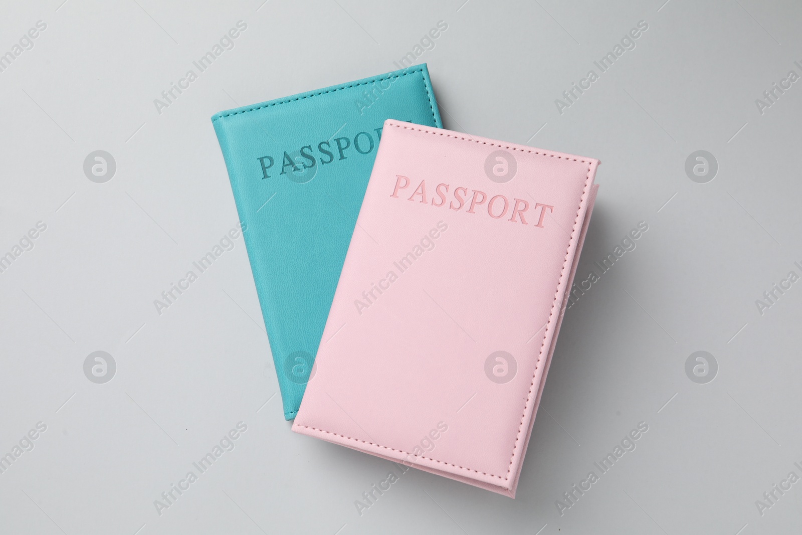 Photo of Passports in color covers on light background, top view