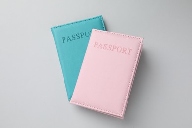 Photo of Passports in color covers on light background, top view