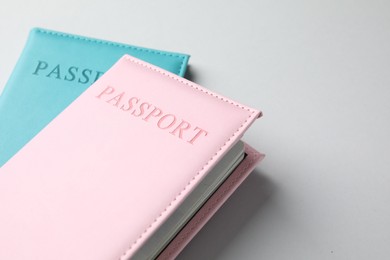 Photo of Passports in color covers on light background, closeup. Space for text