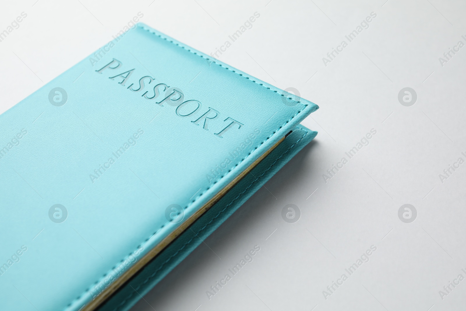 Photo of Passport in blue cover on light background, closeup. Space for text