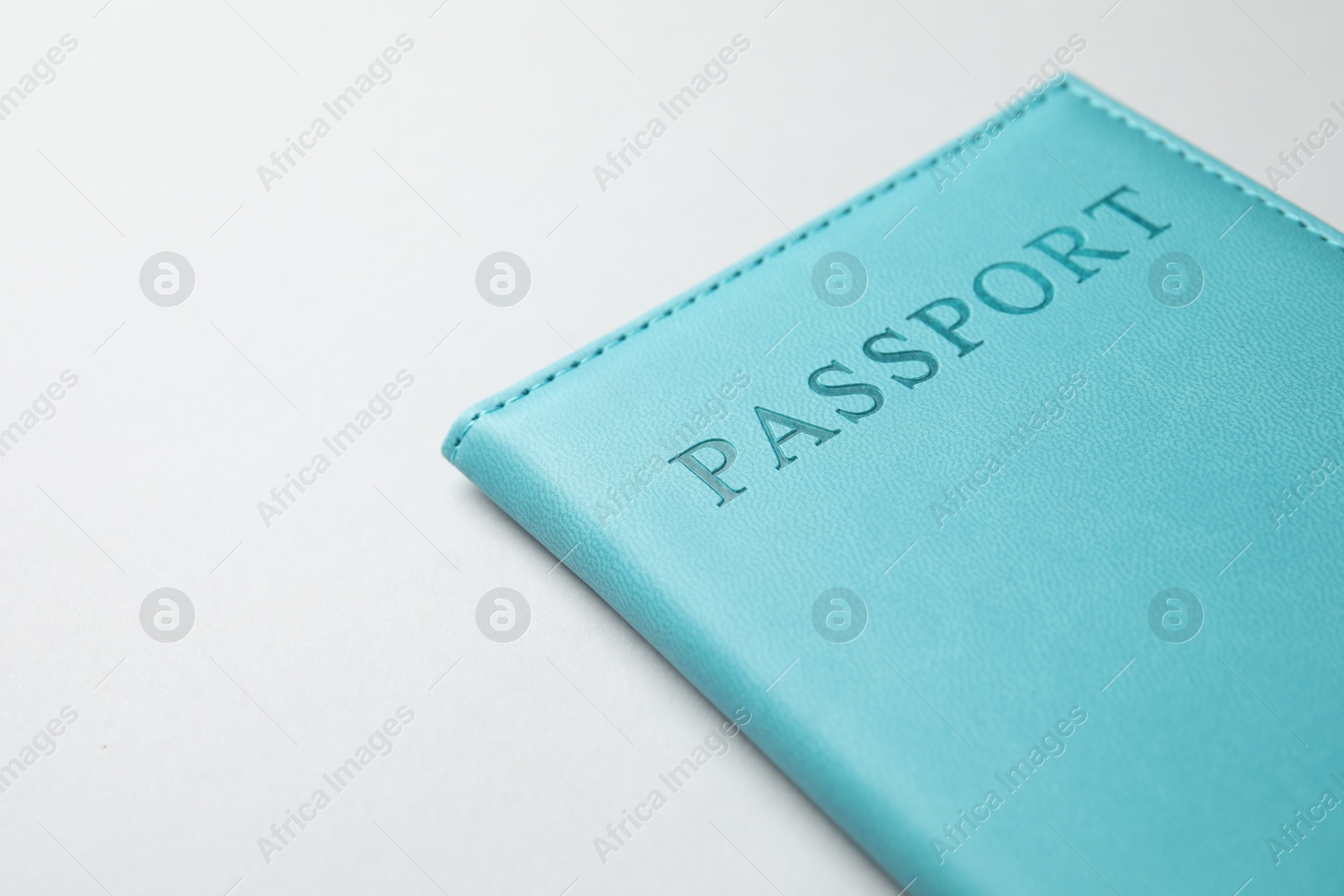 Photo of Passport in blue cover on light background, closeup. Space for text