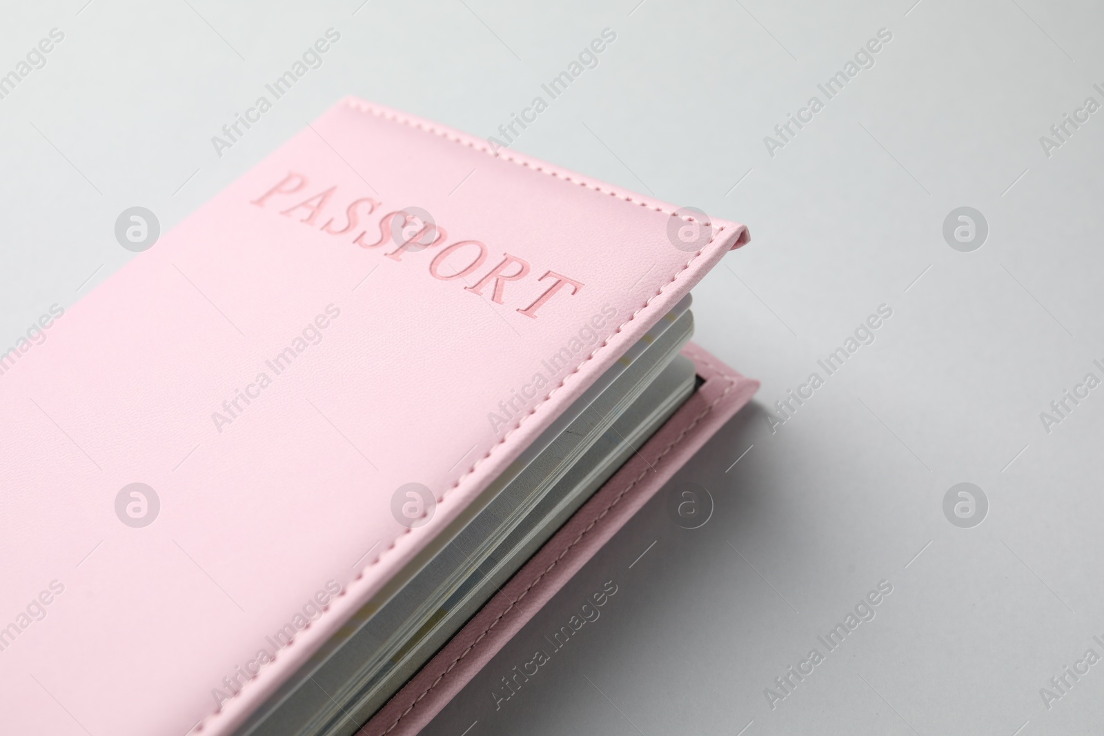 Photo of Passport in pink cover on light background, closeup. Space for text