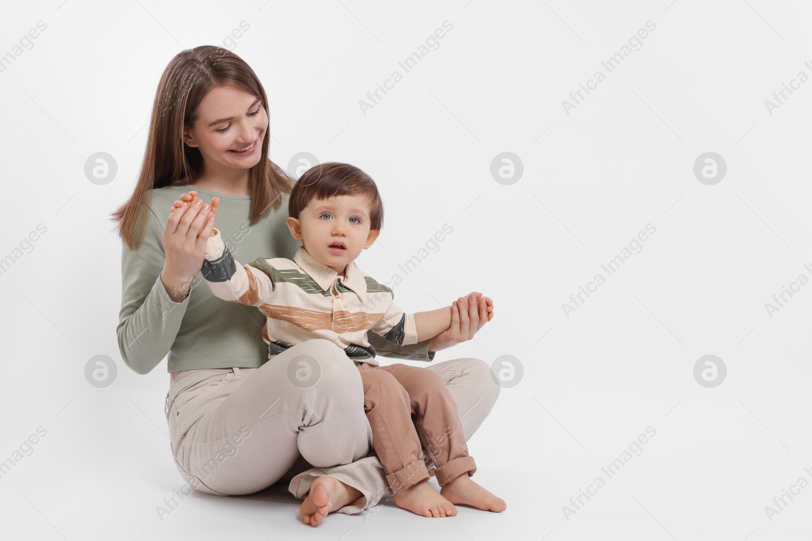 Photo of Happy mother with her cute little son on white background, space for text