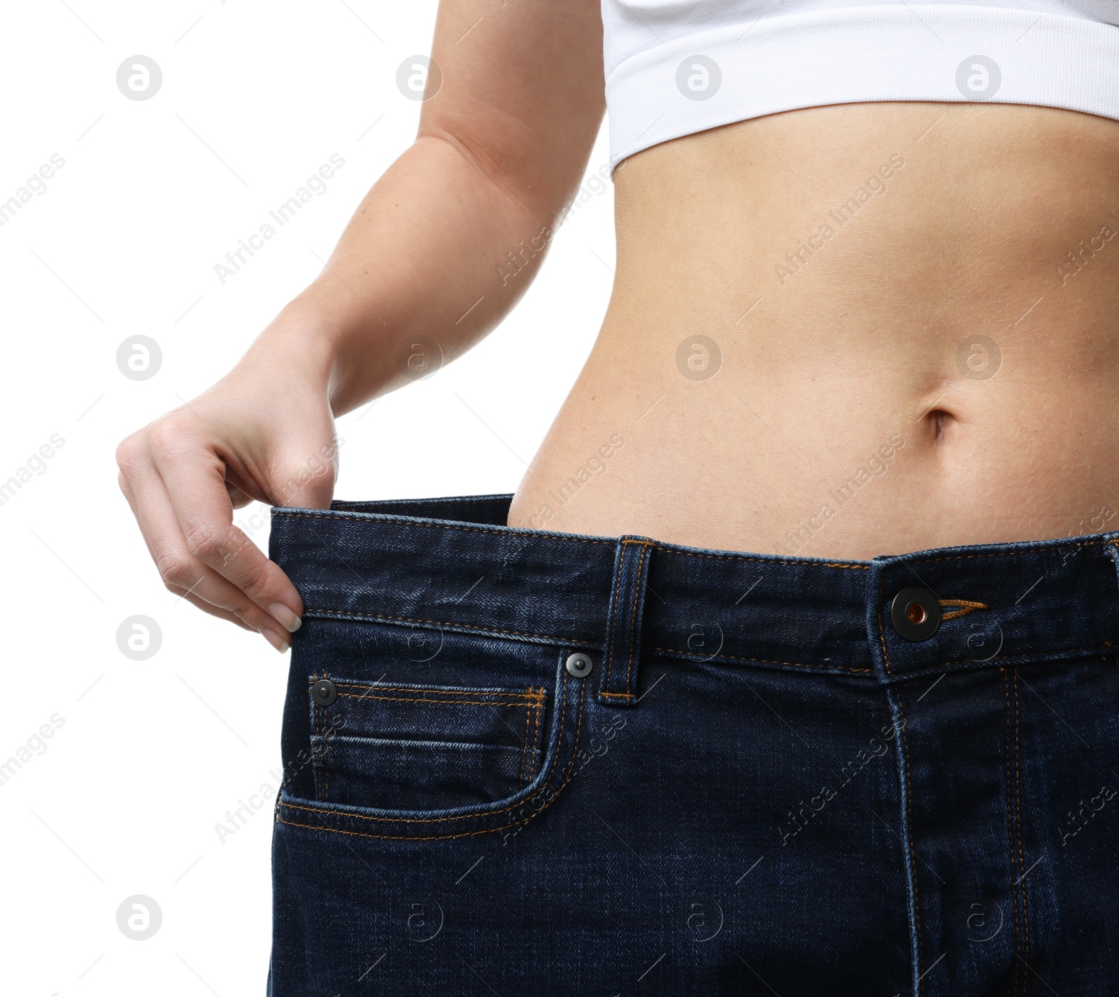 Photo of Weight loss. Woman wearing big jeans on white background, closeup