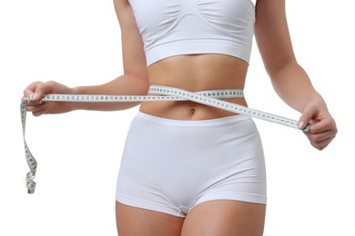 Photo of Weight loss. Woman measuring her slim waist with tape on white background, closeup