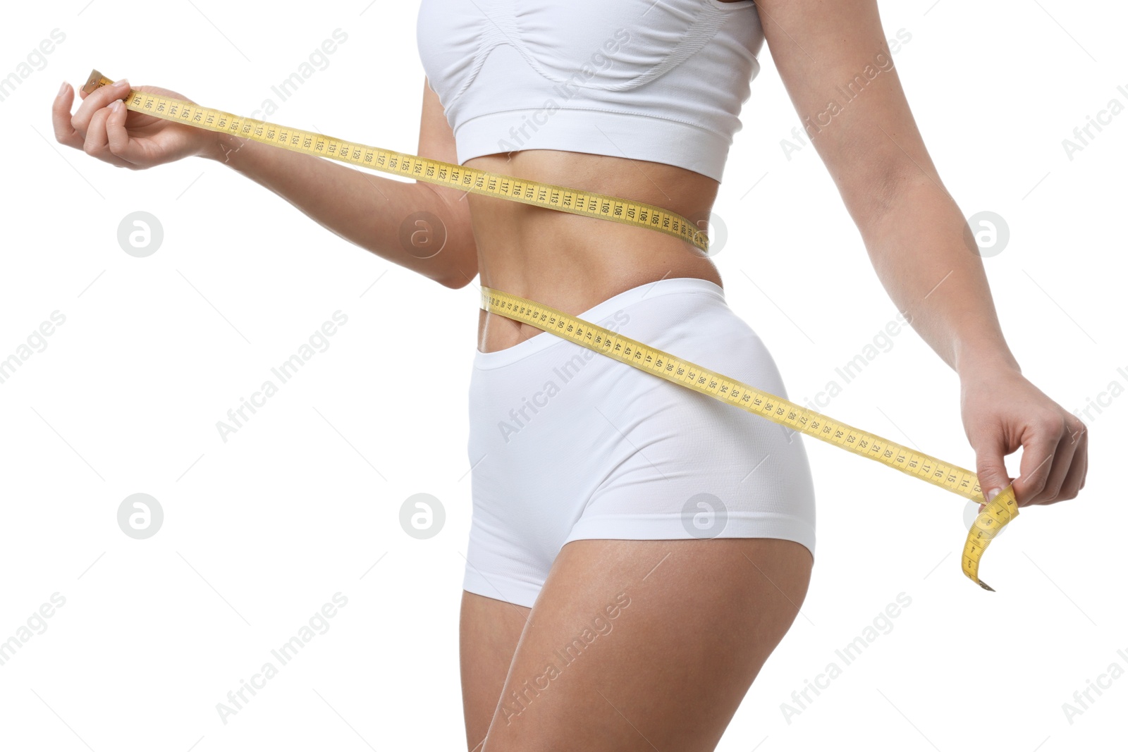 Photo of Weight loss. Woman measuring her slim waist with tape on white background, closeup