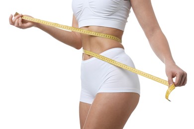 Photo of Weight loss. Woman measuring her slim waist with tape on white background, closeup