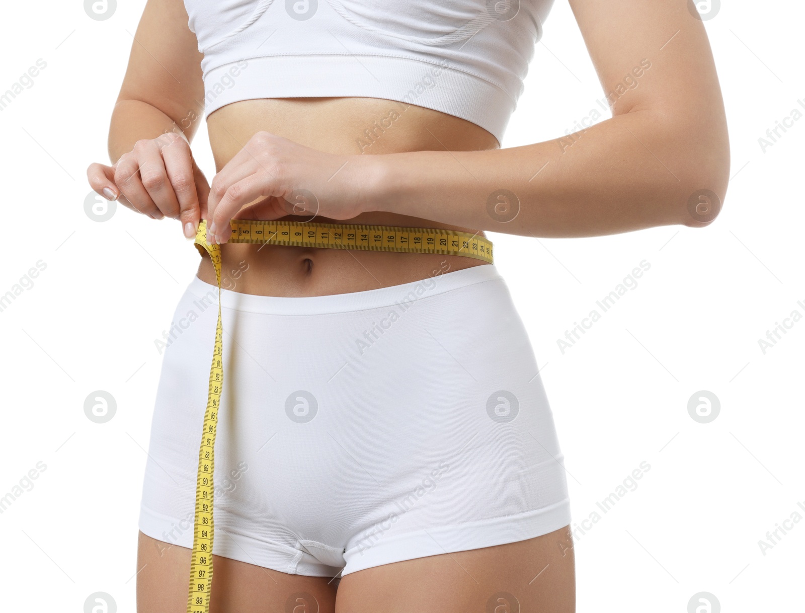 Photo of Weight loss. Woman measuring her slim waist with tape on white background, closeup