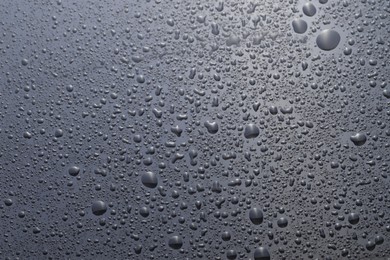 Water drops on grey glass surface, top view