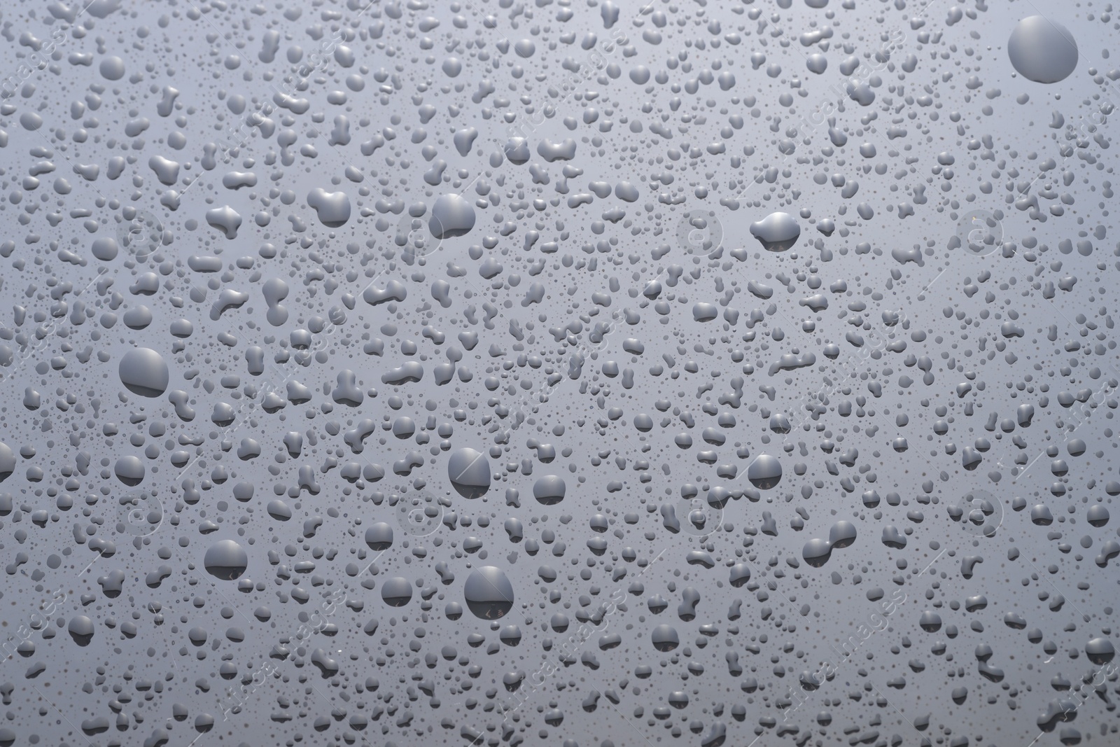 Photo of Water drops on grey glass surface, top view