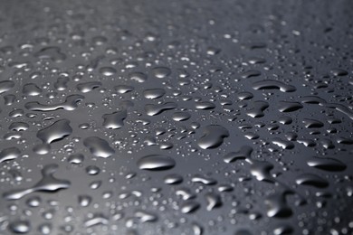 Water drops on grey glass surface, closeup