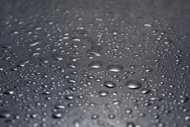 Water drops on grey glass surface, closeup