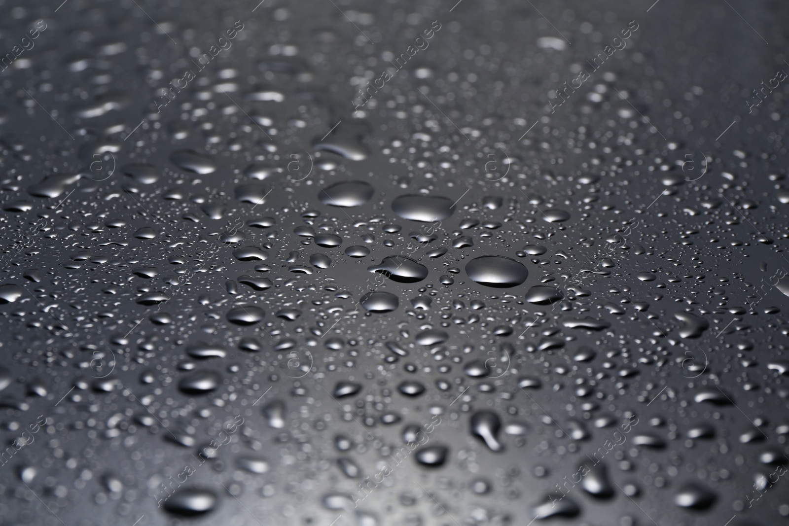 Photo of Water drops on grey glass surface, closeup