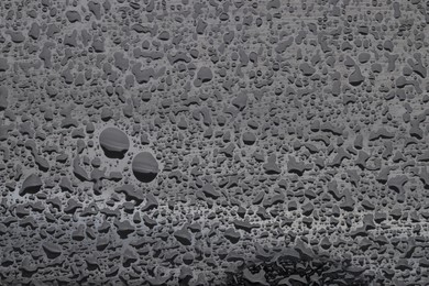 Water drops on grey glass surface, top view