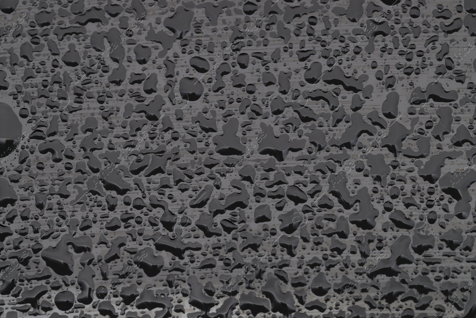 Photo of Water drops on grey glass surface, top view