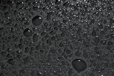 Photo of Water drops on grey glass surface, top view