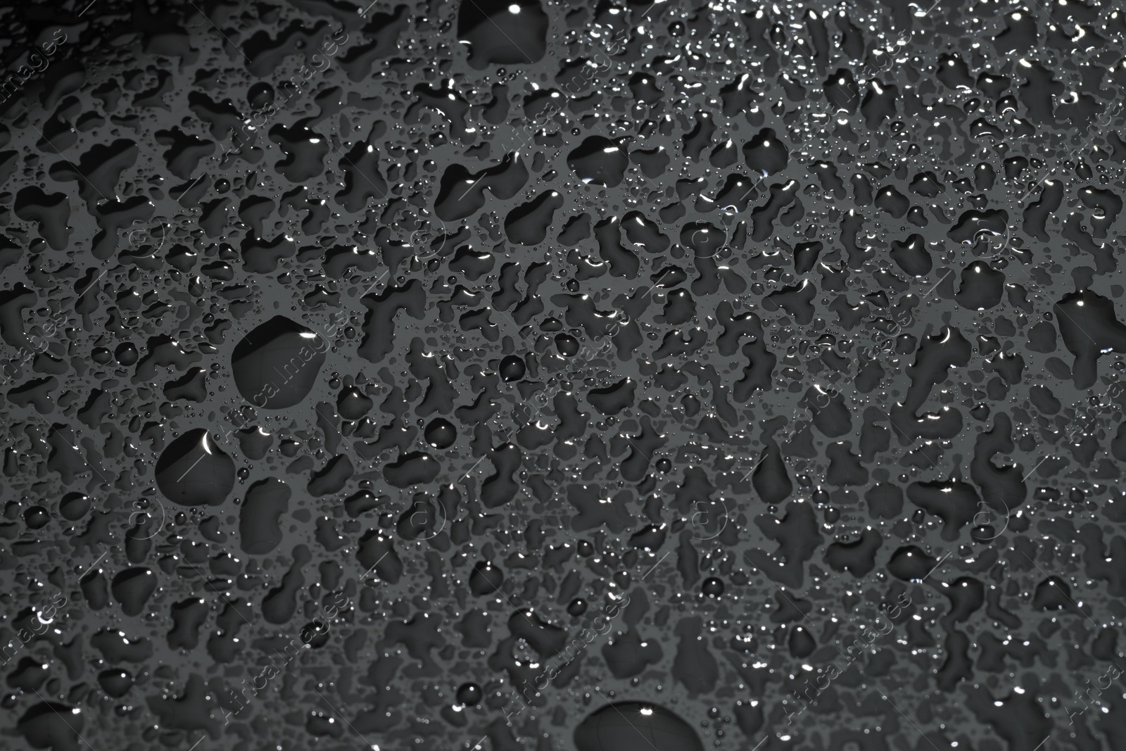 Photo of Water drops on grey glass surface, top view