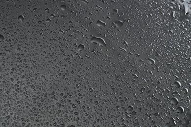 Water drops on grey glass surface, top view