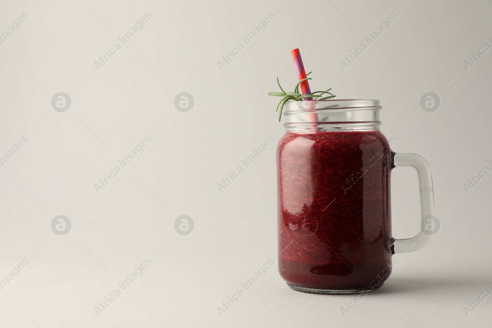 Photo of Fresh beetroot smoothie in mason jar on light grey background. Space for text