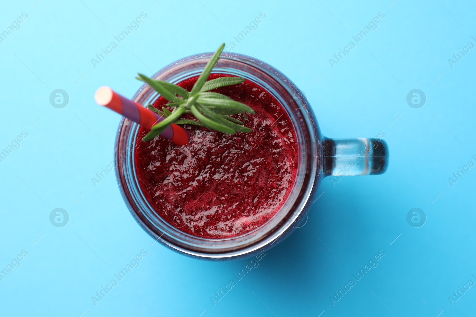 Photo of Fresh beetroot smoothie with rosemary in mason jar on light blue background, top view