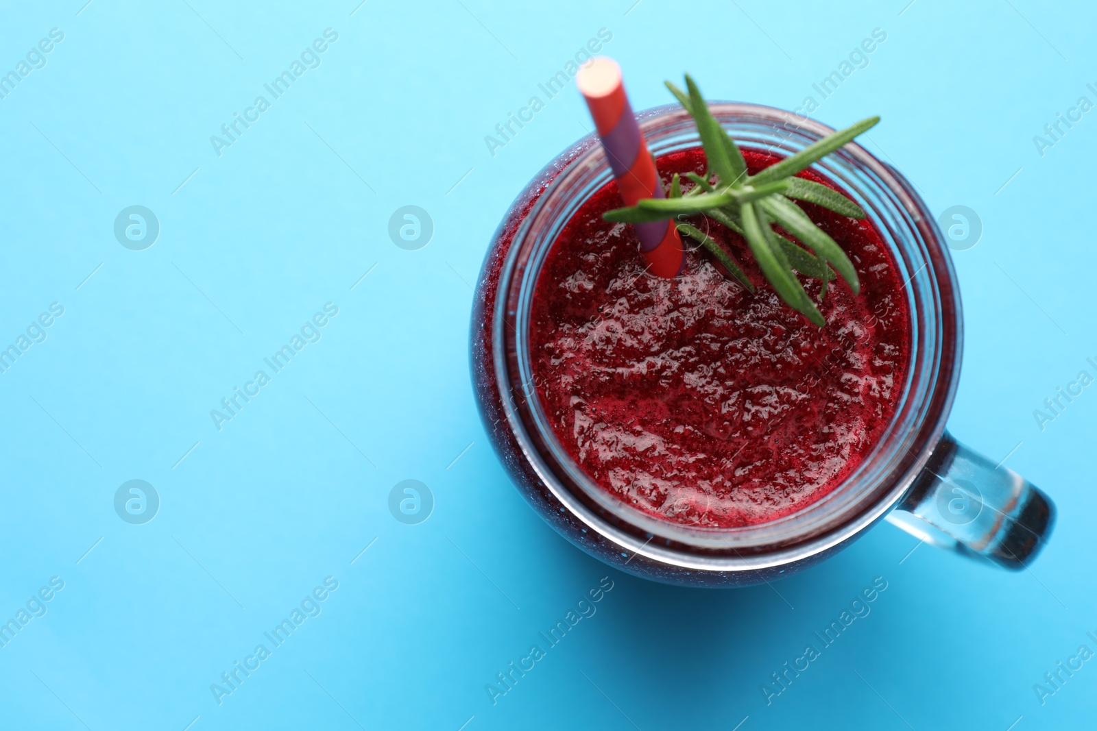 Photo of Fresh beetroot smoothie with rosemary in mason jar on light blue background, top view. Space for text