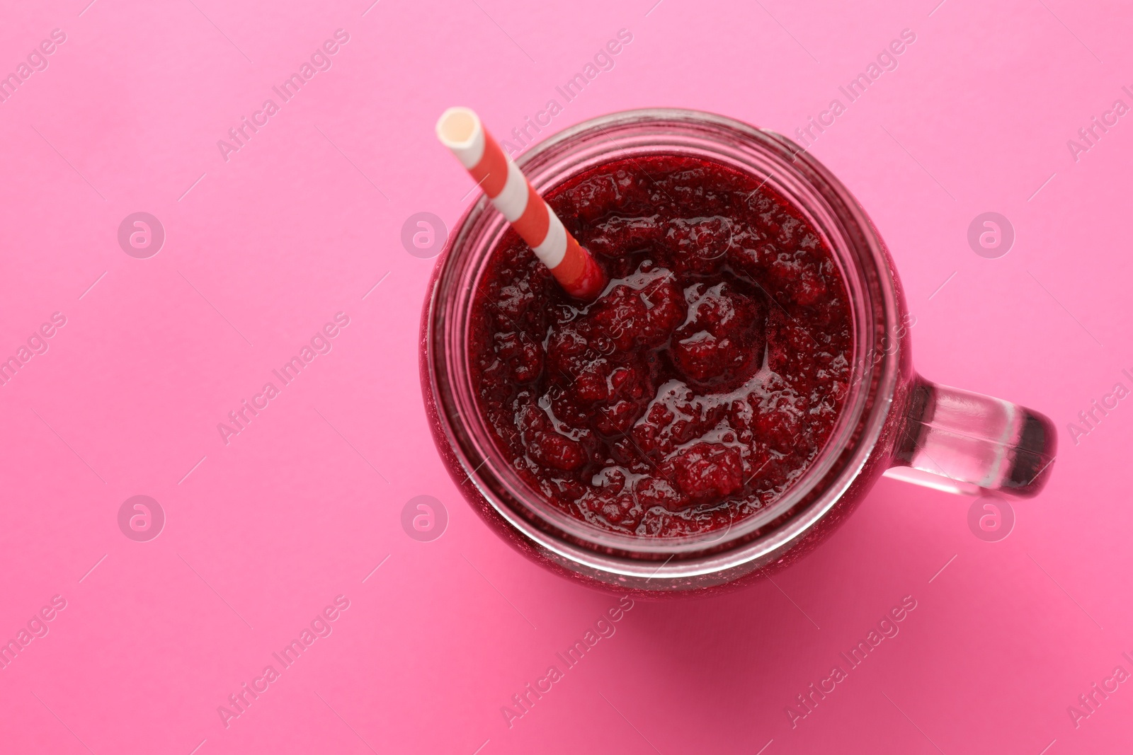 Photo of Fresh beetroot smoothie in mason jar on pink background, top view. Space for text