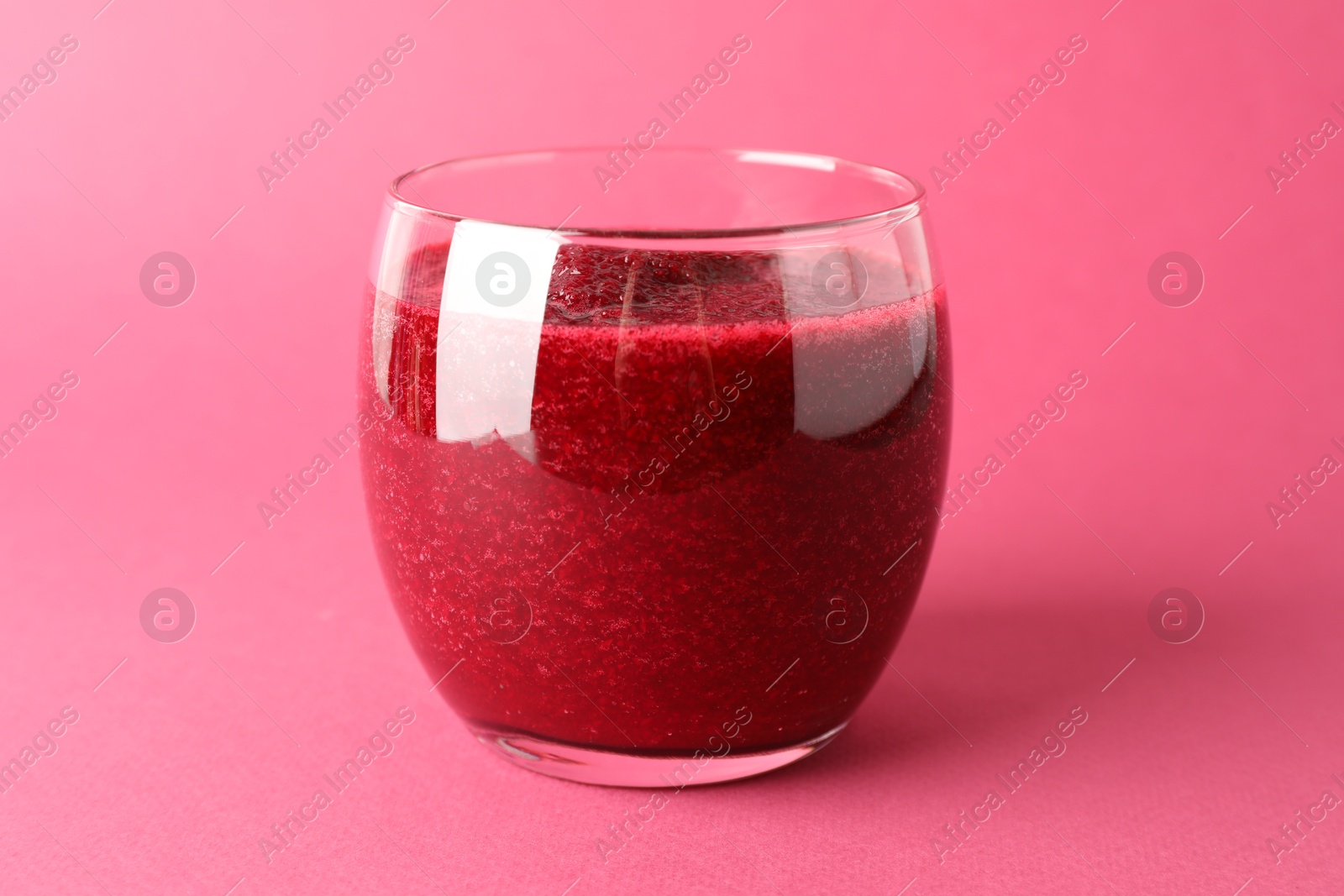 Photo of Fresh beetroot smoothie in glass on pink background, closeup