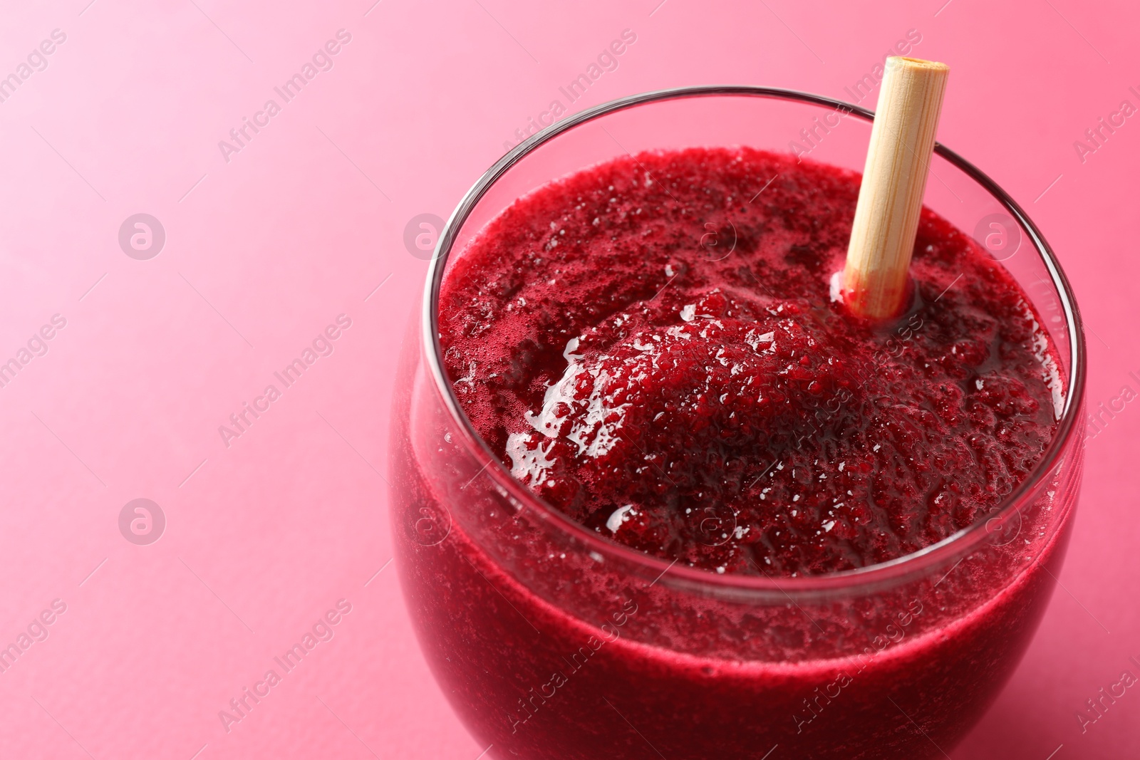 Photo of Fresh beetroot smoothie in glass on pink background, closeup. Space for text