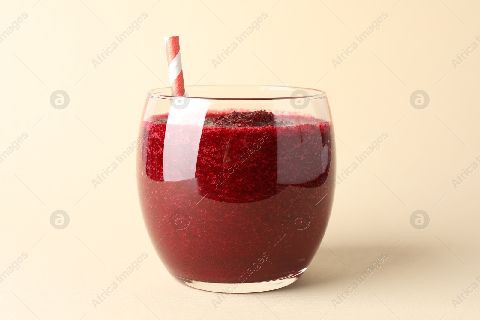 Photo of Fresh beetroot smoothie in glass on beige background, closeup