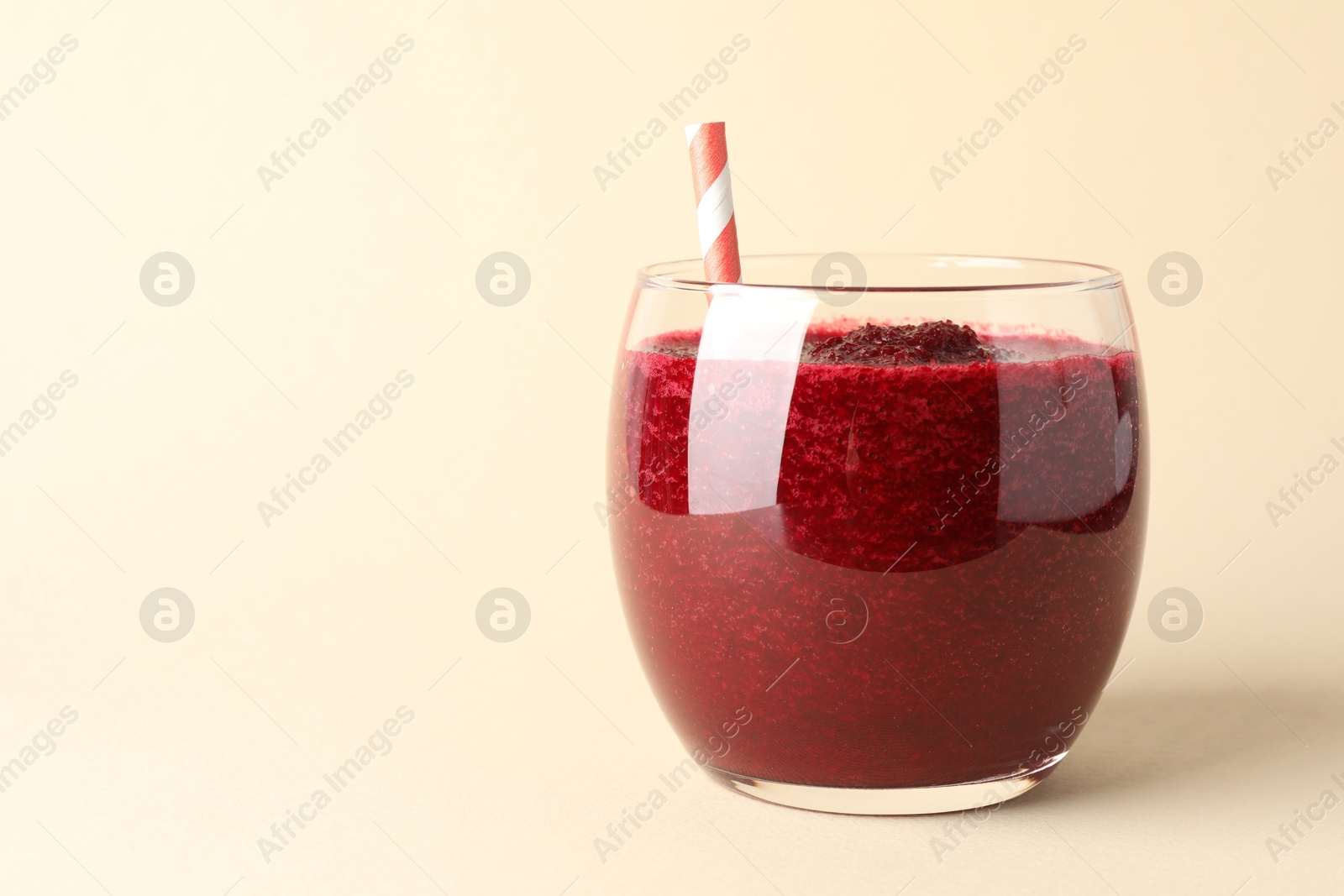 Photo of Fresh beetroot smoothie in glass on beige background, closeup. Space for text