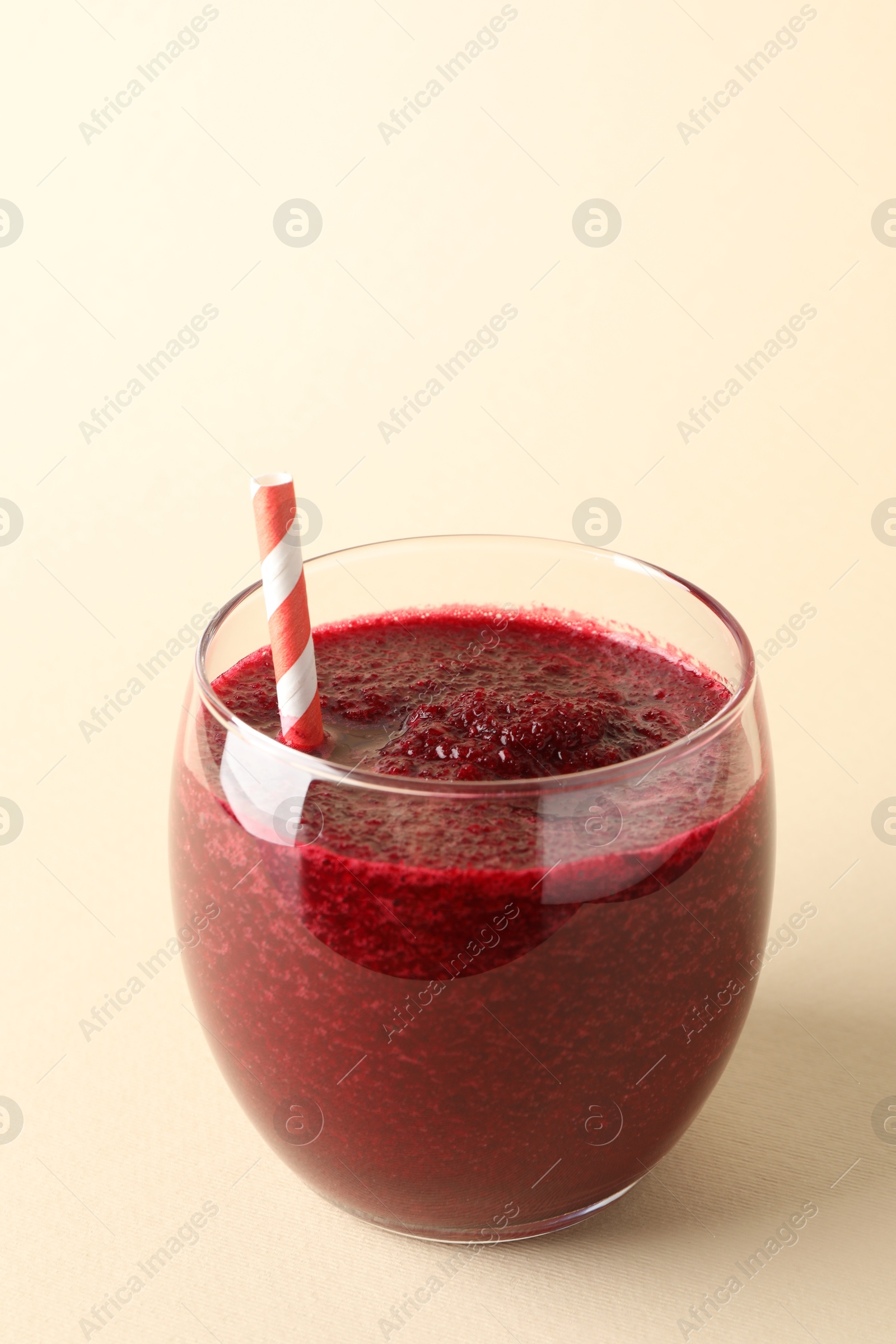 Photo of Fresh beetroot smoothie in glass on beige background, closeup