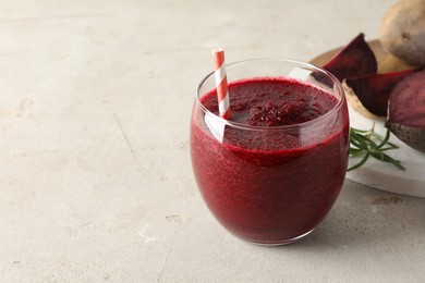 Photo of Fresh beetroot smoothie in glass on grey textured table, closeup. Space for text