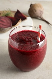 Photo of Fresh beetroot smoothie in glass on grey textured table, closeup