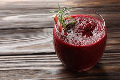 Photo of Fresh beetroot smoothie with rosemary in glass on wooden table, closeup. Space for text