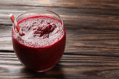 Photo of Fresh beetroot smoothie in glass on wooden table, closeup. Space for text