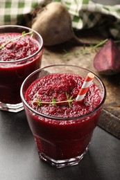 Photo of Fresh beetroot smoothie in glasses on grey textured table, closeup