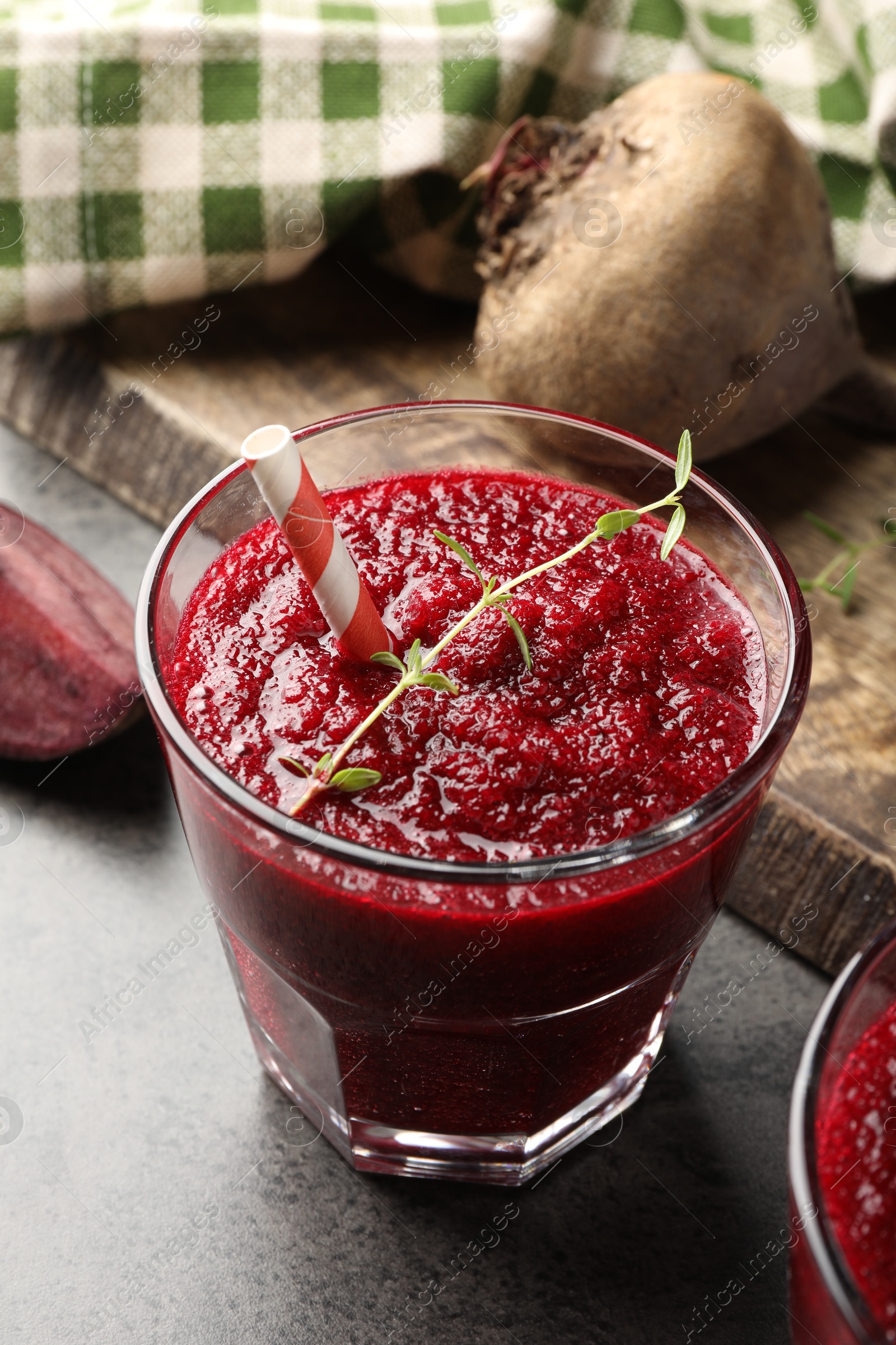 Photo of Fresh beetroot smoothie in glass on grey textured table, closeup