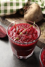 Photo of Fresh beetroot smoothie in glass on grey textured table, closeup