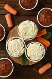 Photo of Tasty carrot muffins and fresh vegetables on wooden table, flat lay