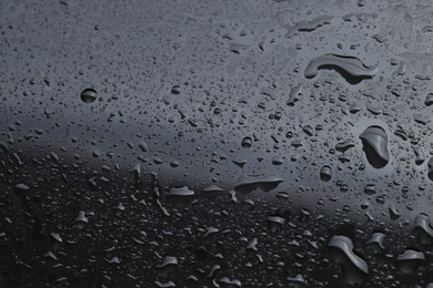 Photo of Water drops on grey glass surface, closeup